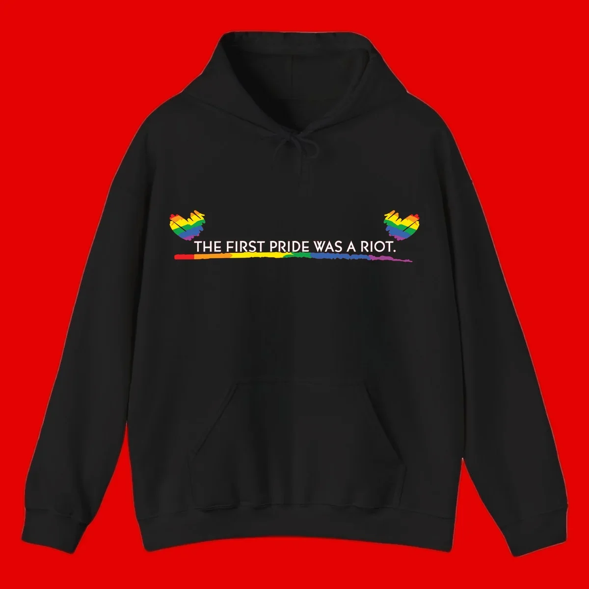 Gray background with white text reading 'THE FIRST PRIDE WAS A RIOT' surrounded by rainbow pride hearts and gradient stripe