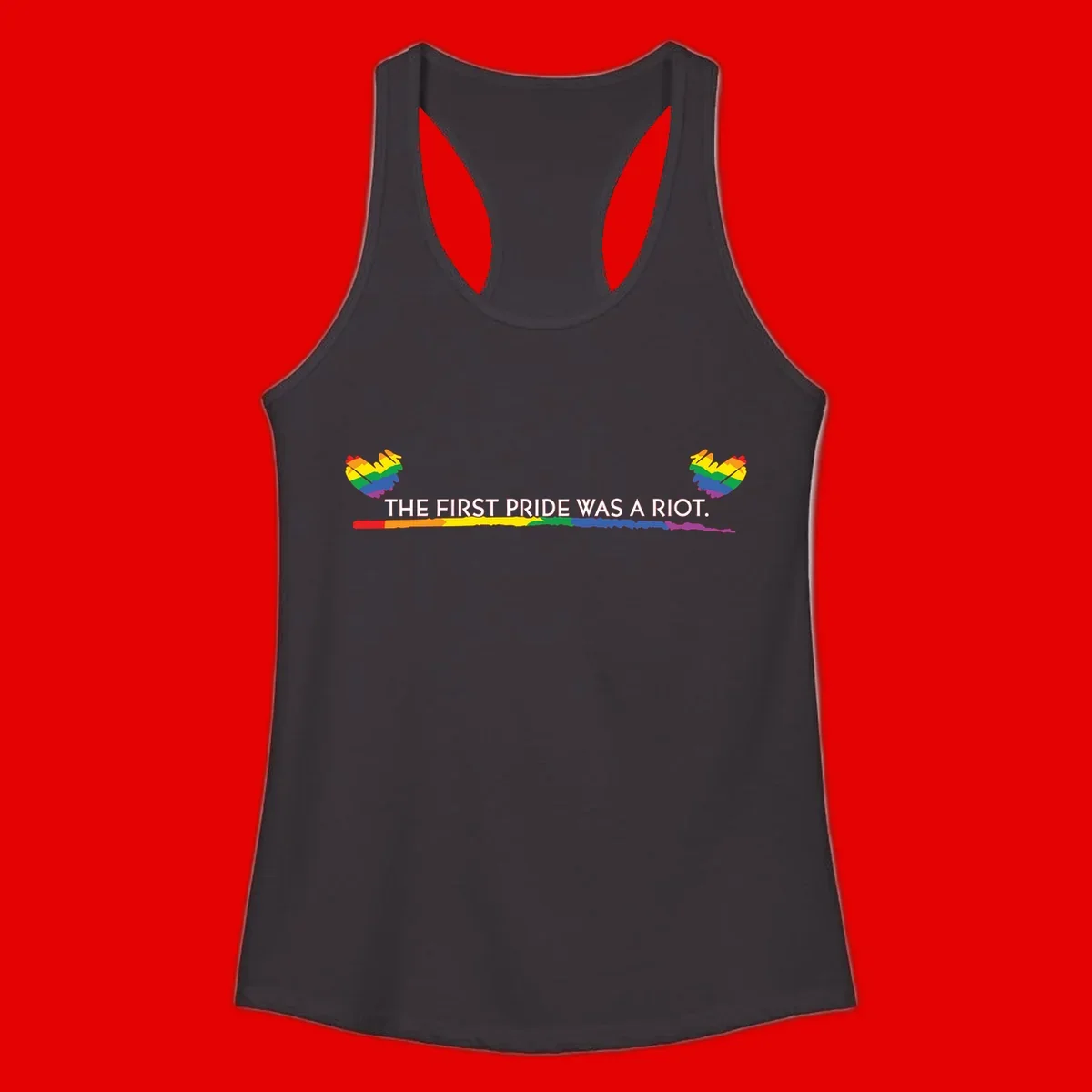 Gray background with white text reading 'THE FIRST PRIDE WAS A RIOT' surrounded by rainbow pride hearts and gradient stripe