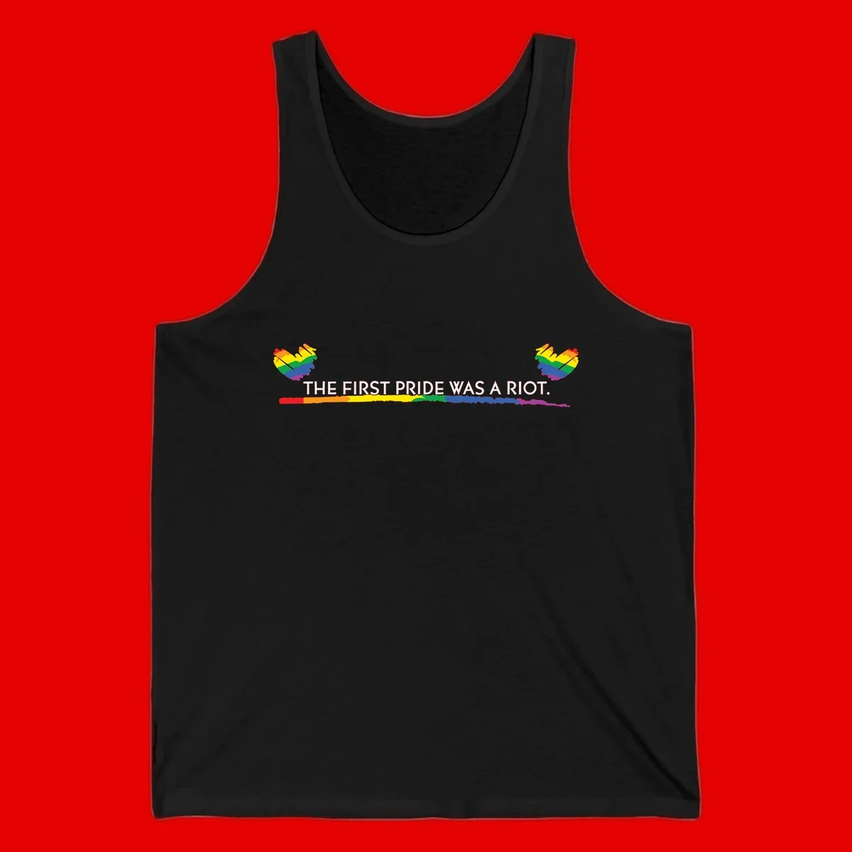 Gray background with white text reading 'THE FIRST PRIDE WAS A RIOT' surrounded by rainbow pride hearts and gradient stripe