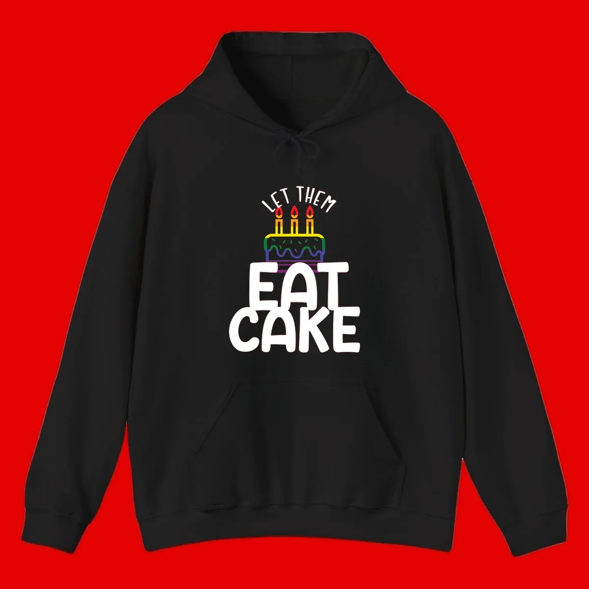 Rainbow-layered birthday cake with three candles above bold white text reading 'Let Them Eat Cake' - a Pride-themed design
