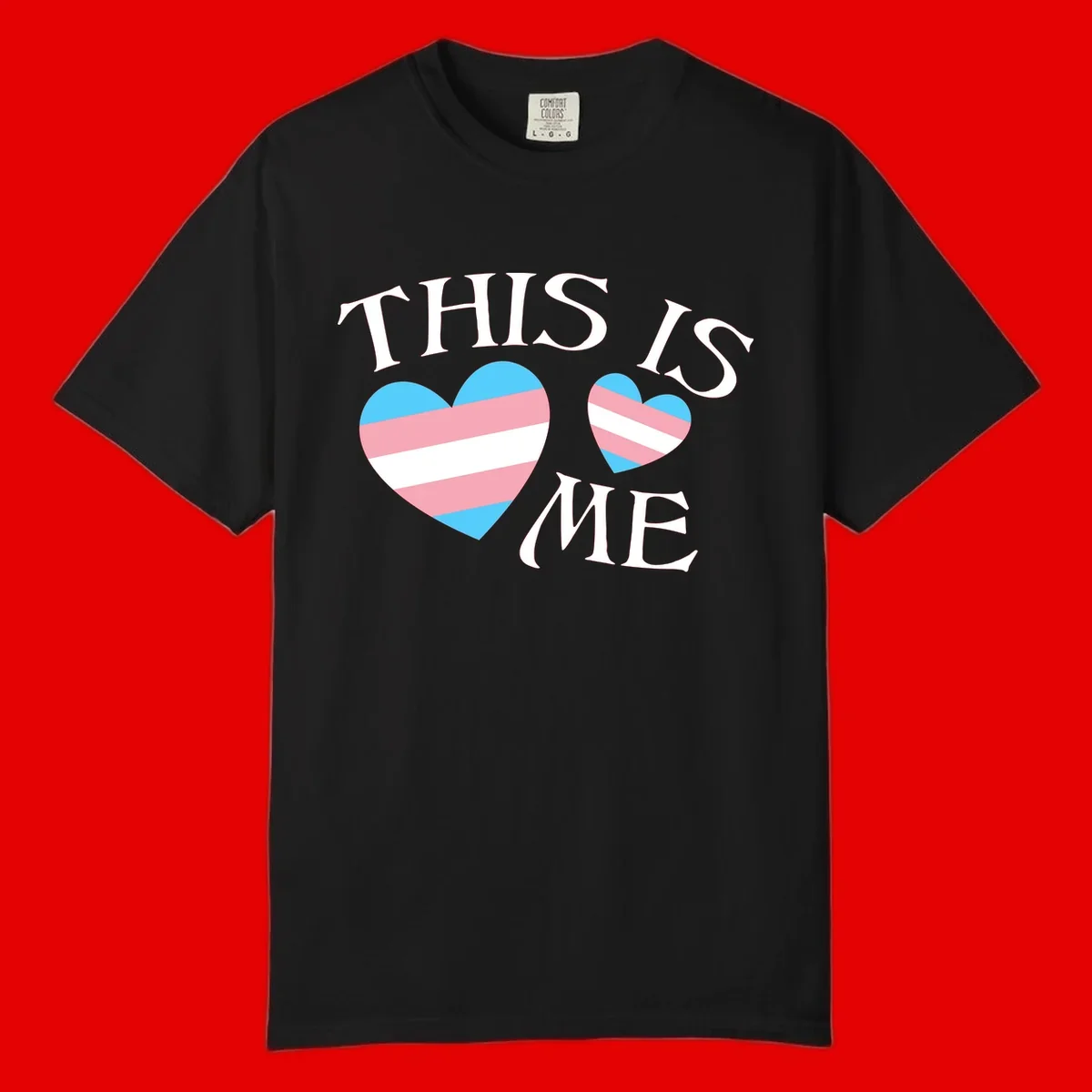Two striped hearts in trans flag colors (blue, pink, white) with 'THIS IS ME' text celebrating trans pride and identity