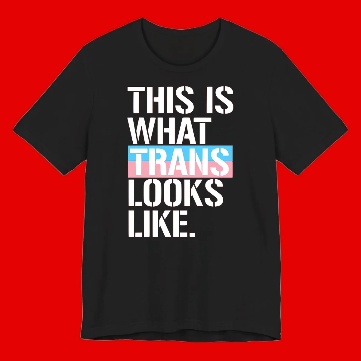 Bold typography design reading 'THIS IS WHAT TRANS LOOKS LIKE' with trans pride flag colors in blue and pink stripe