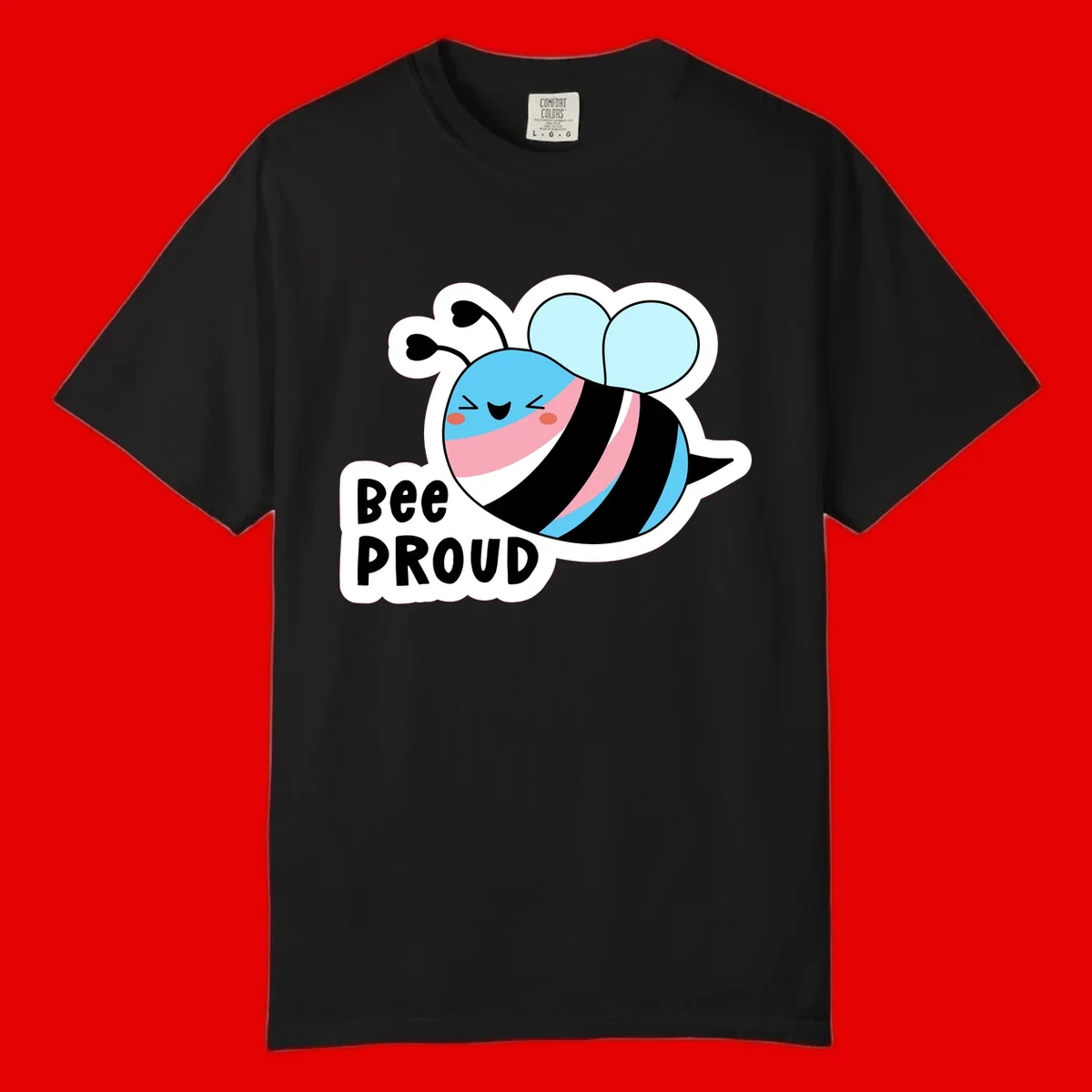 Smiling cartoon bee with blue head, pink mouth, striped body, and light blue wings next to 'Bee Proud' text