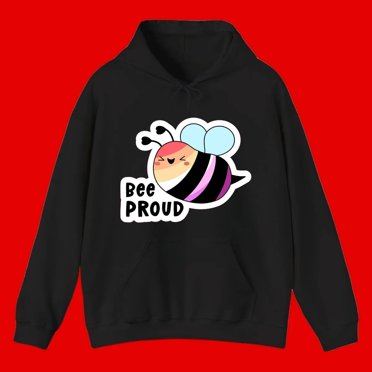 Cheerful cartoon bee with peach face and pink-striped body next to 'Bee Proud' text celebrating pride and individuality