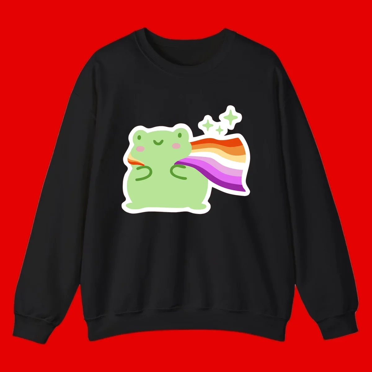 Cute green frog with pink cheeks wearing a rainbow pride cape, surrounded by sparkle stars