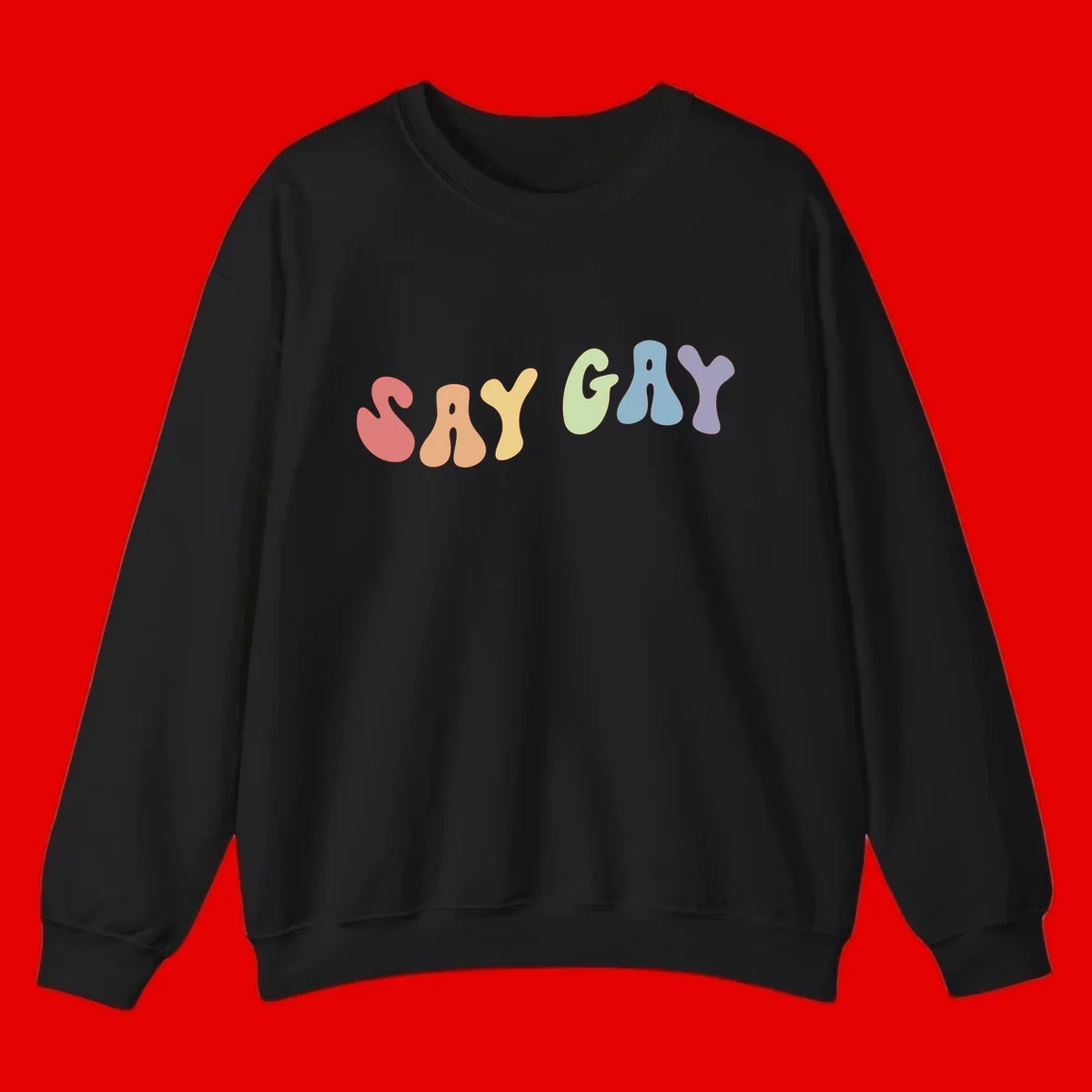 Colorful bubble letters spelling SAY GAY in rainbow pride colors: red, peach, yellow, green, blue, and purple on gray background