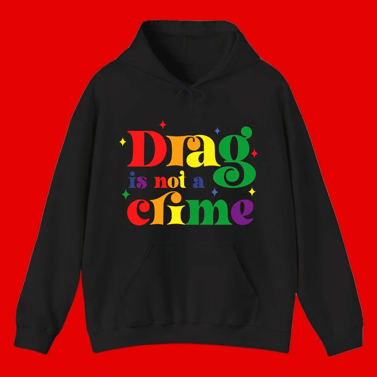 Colorful rainbow typography spelling 'Drag is not a crime' with decorative stars on gray background
