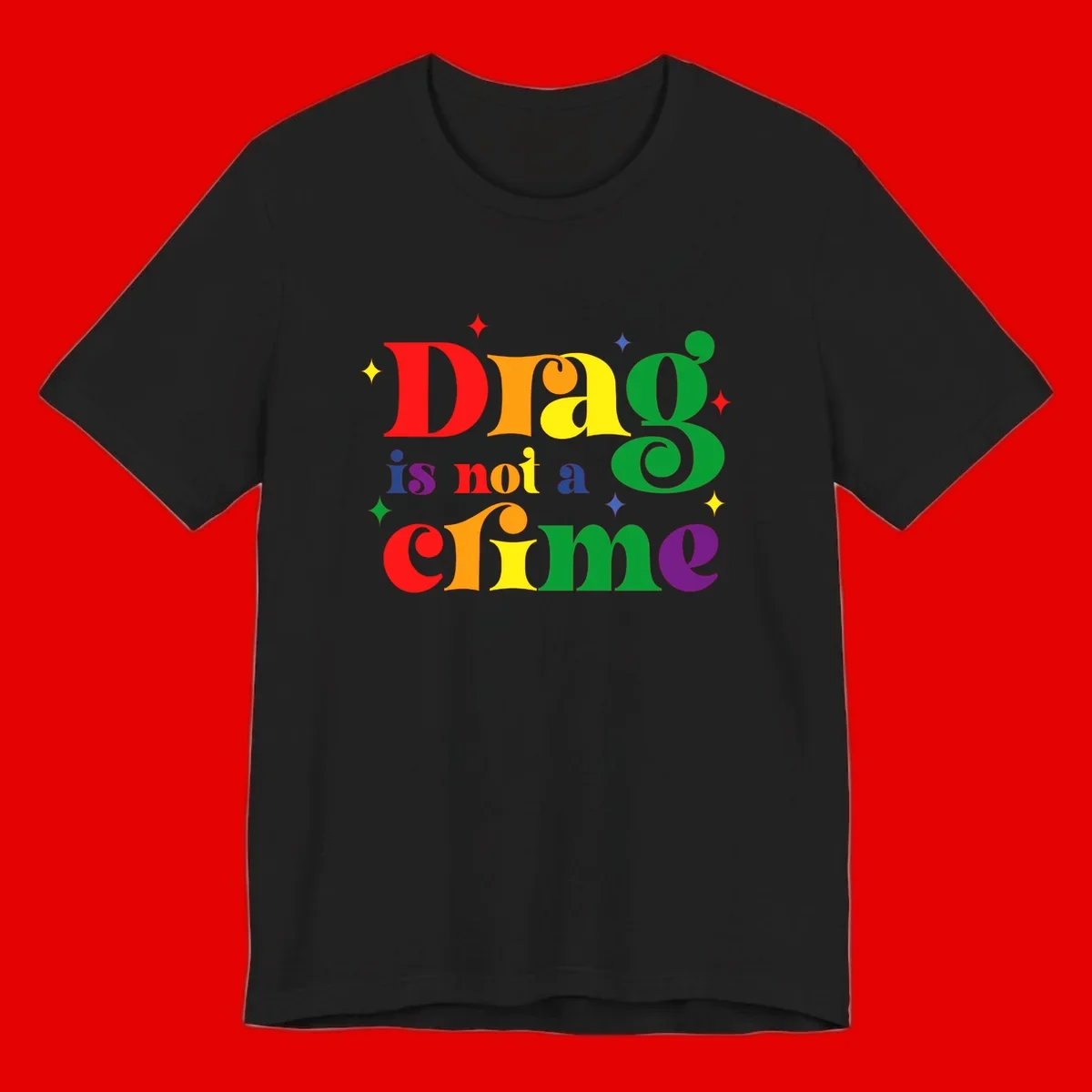 Colorful rainbow typography spelling 'Drag is not a crime' with decorative stars on gray background