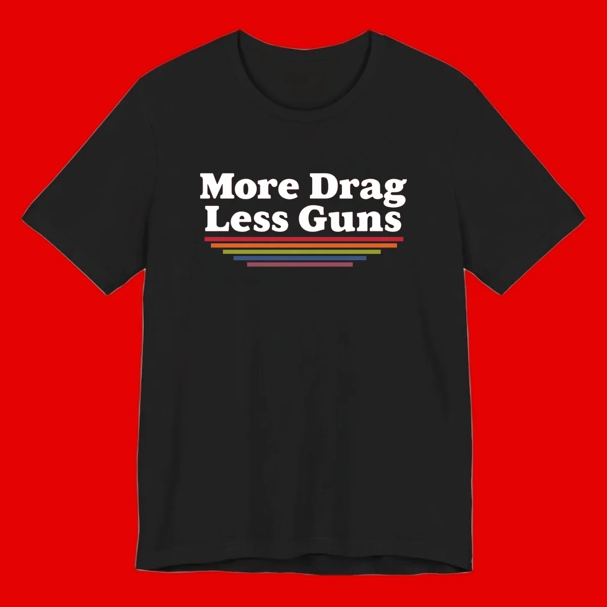More Drag Less Guns design: white text on gray background with colored horizontal bars representing pride and activism