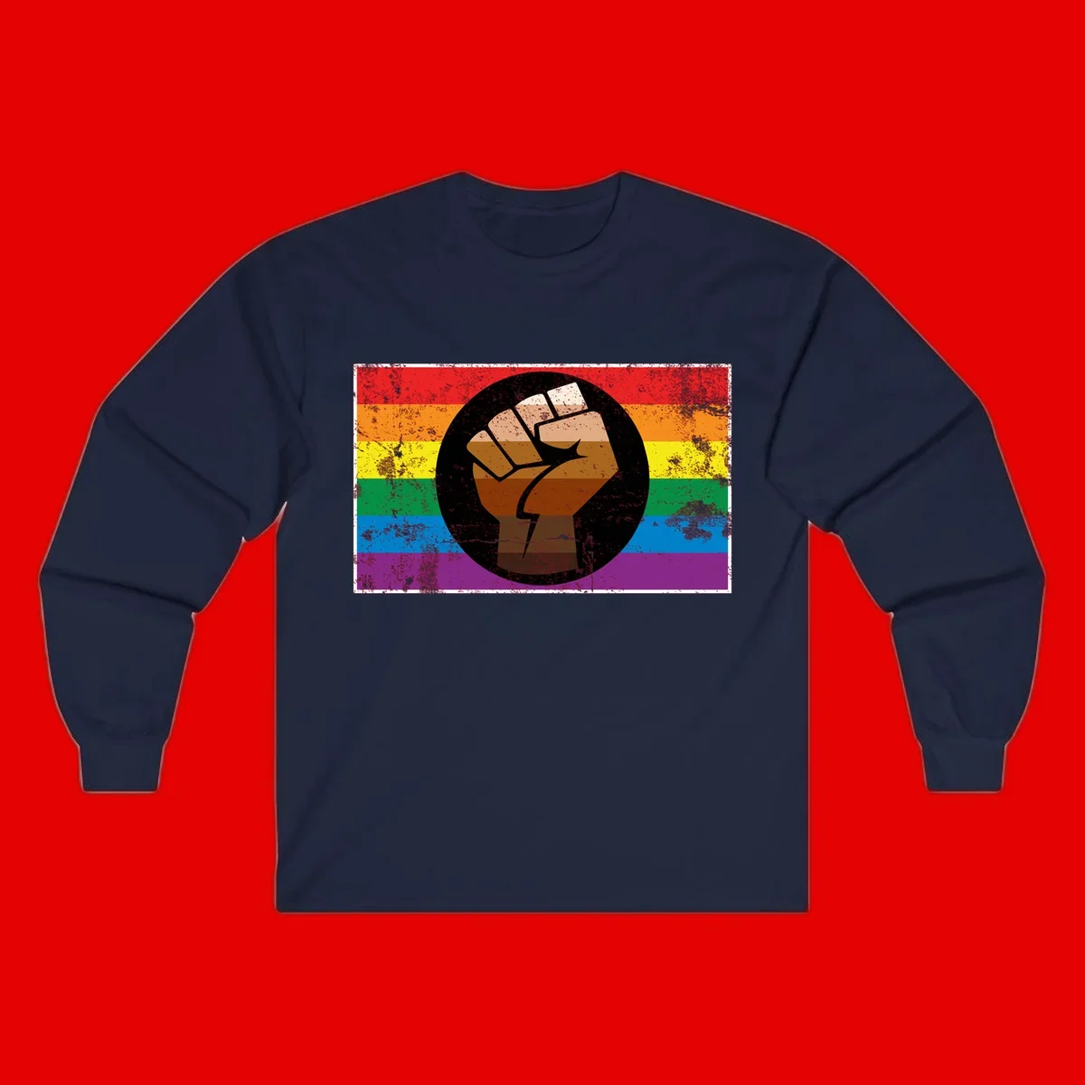 Distressed circular badge featuring a raised brown fist overlaid on a rainbow pride flag background, symbolizing LGBTQ+ solidarity and empowerment