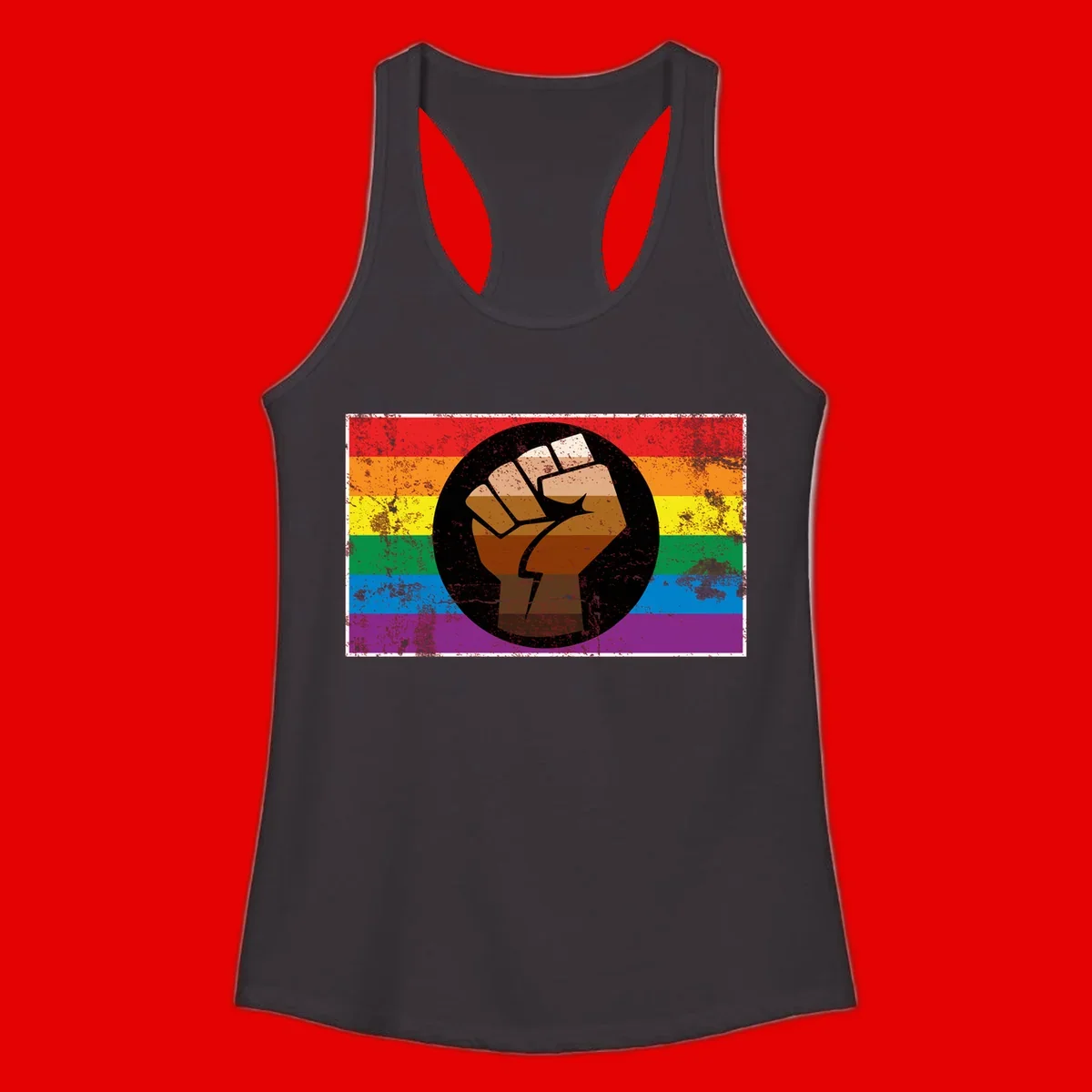 Distressed circular badge featuring a raised brown fist overlaid on a rainbow pride flag background, symbolizing LGBTQ+ solidarity and empowerment