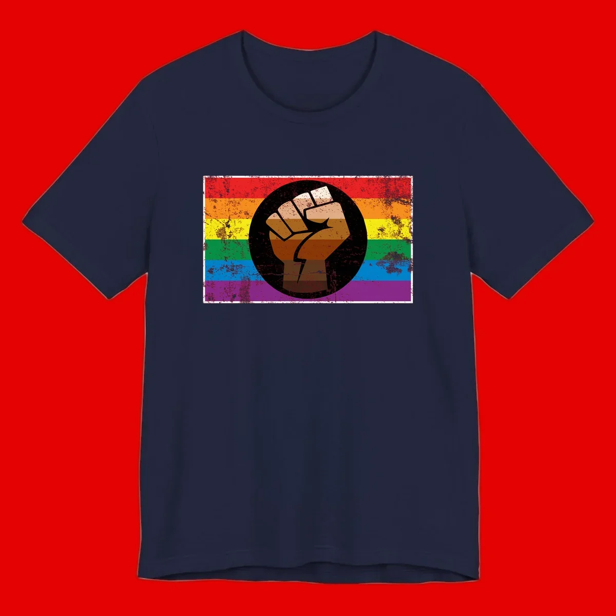 Distressed circular badge featuring a raised brown fist overlaid on a rainbow pride flag background, symbolizing LGBTQ+ solidarity and empowerment