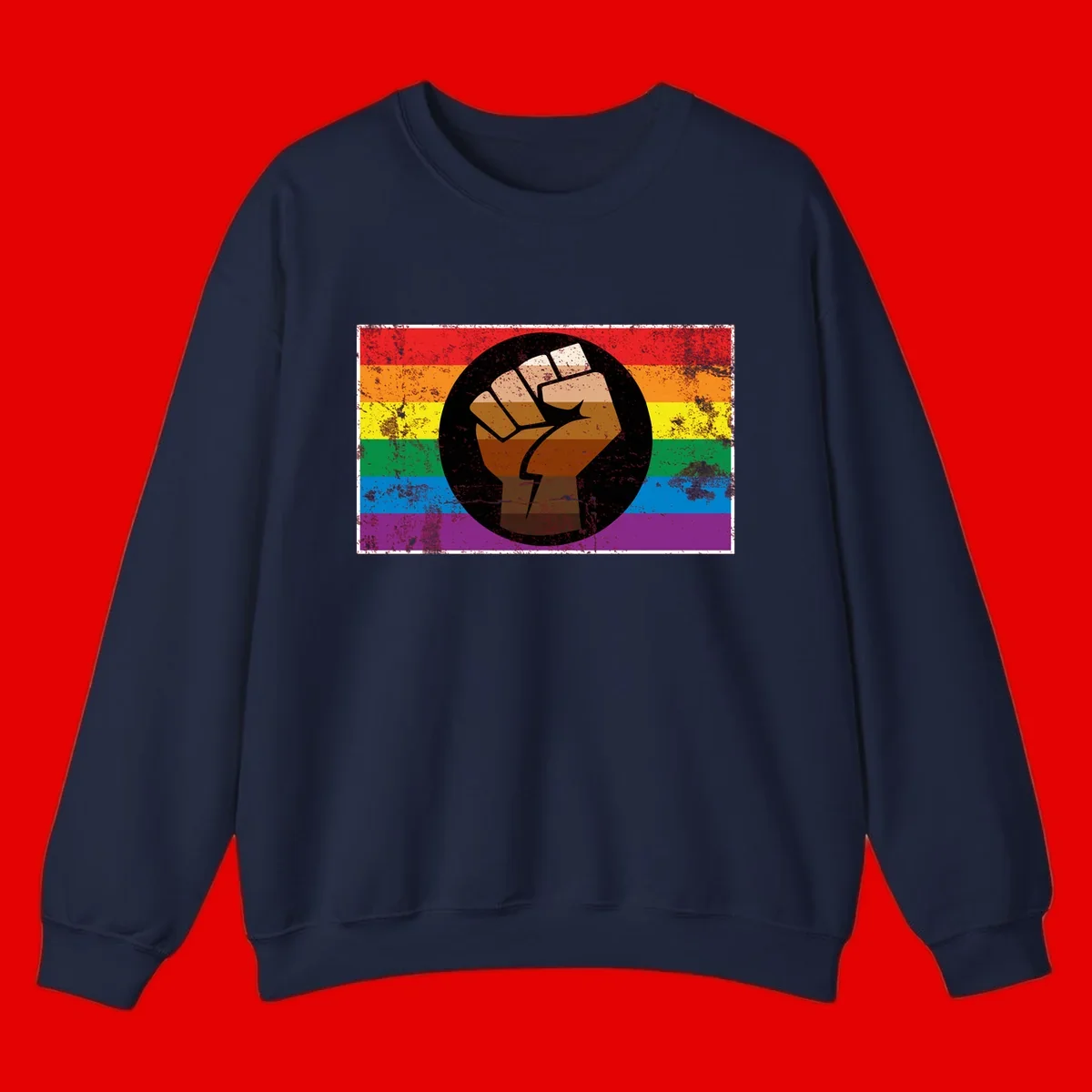 Distressed circular badge featuring a raised brown fist overlaid on a rainbow pride flag background, symbolizing LGBTQ+ solidarity and empowerment