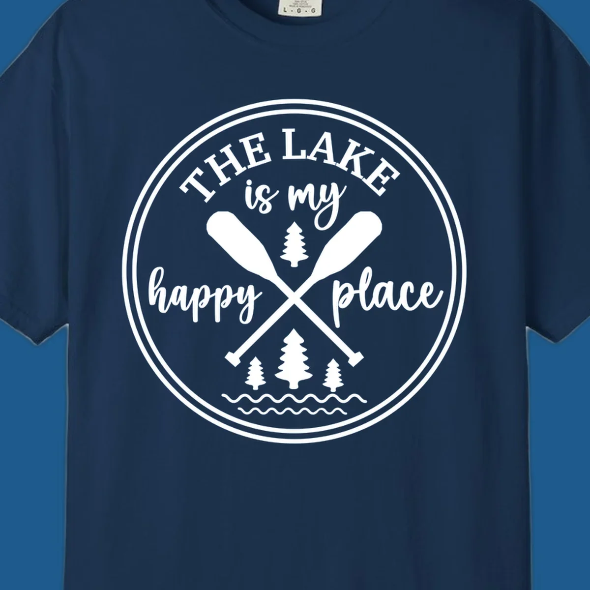 Circular graphic with text 'The Lake is my happy place', crossed oars, and pine trees - lake-happy-place.