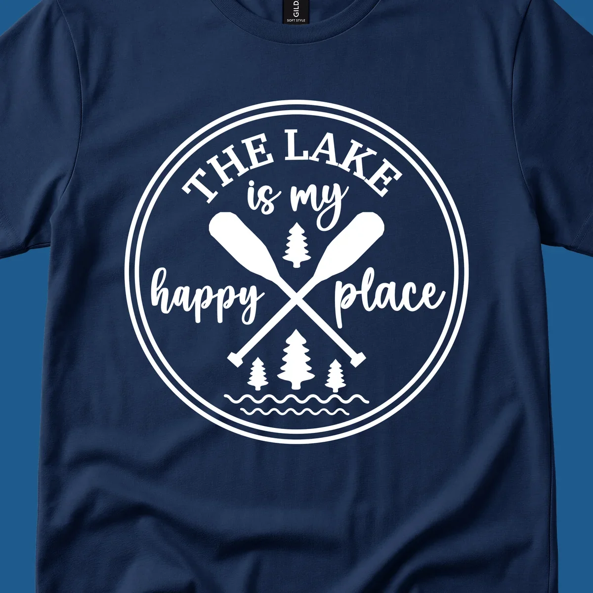 Circular graphic with text 'The Lake is my happy place', crossed oars, and pine trees - lake-happy-place.
