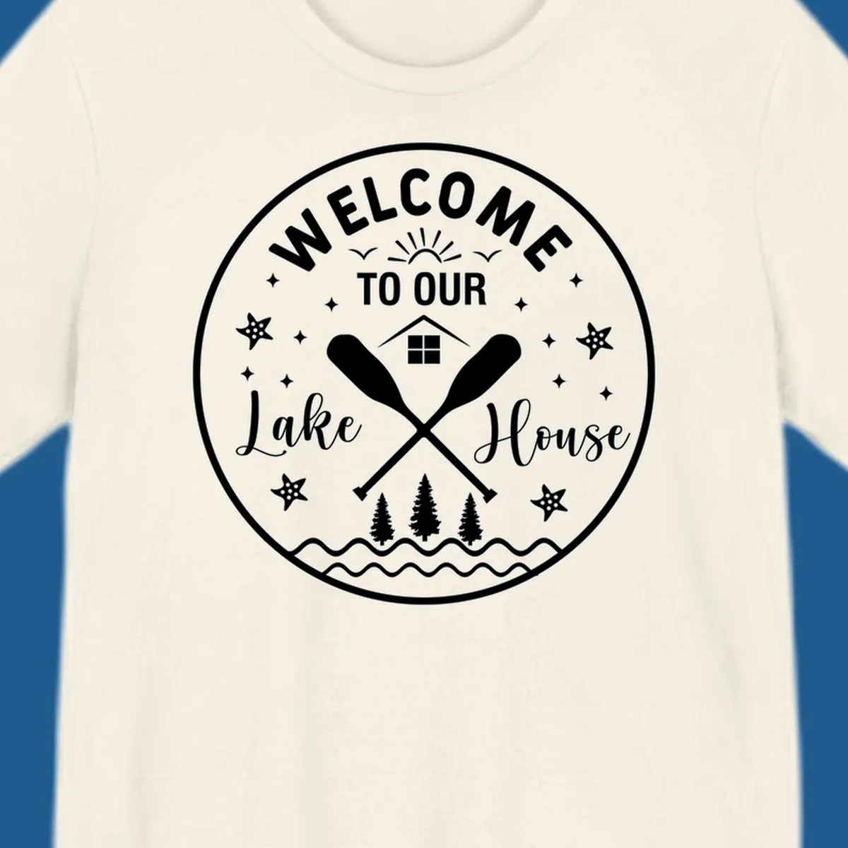 Welcome to our lake house circular design with oars, house, trees, and text.