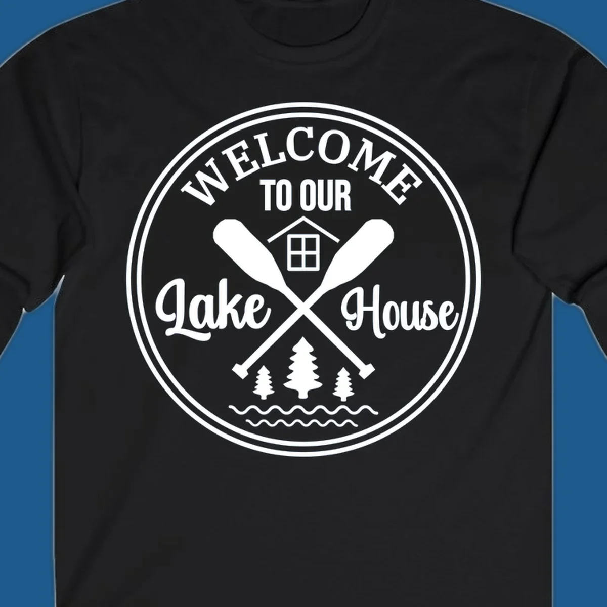 Circular badge design with text 'WELCOME TO OUR Lake House', crossed oars, house, trees, and waves.