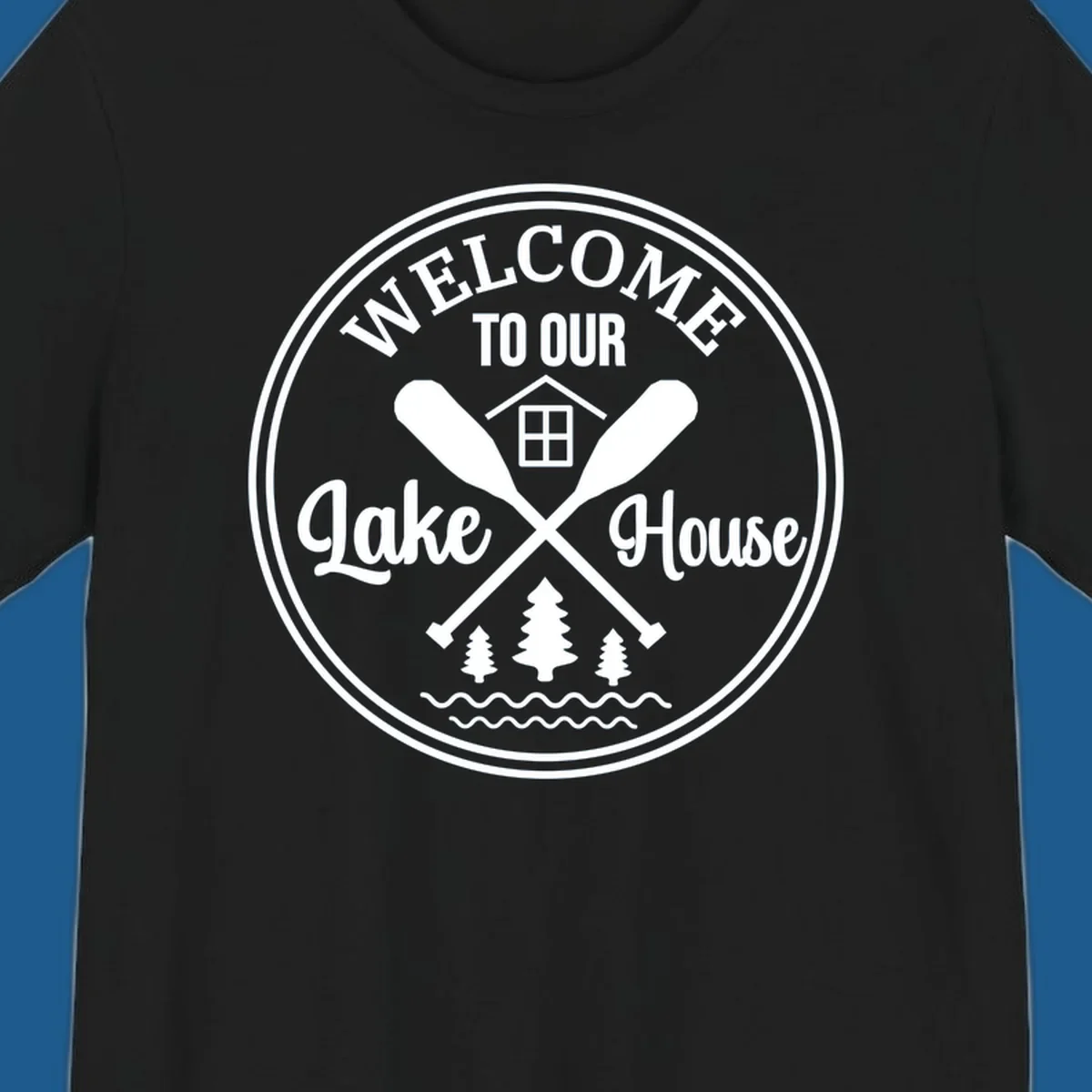 Circular badge design with text 'WELCOME TO OUR Lake House', crossed oars, house, trees, and waves.