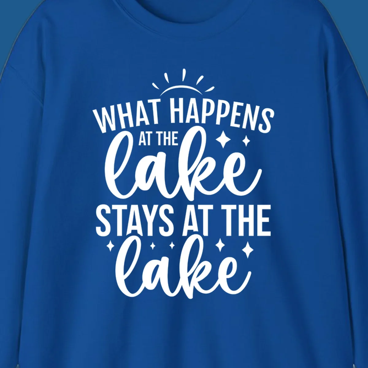 What happens at the lake stays at the lake typography design with sun rays and sparkles.