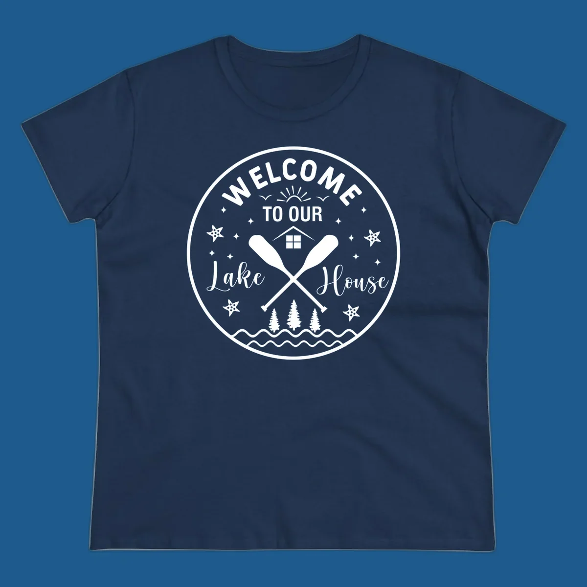 Welcome to our lake house circular design with oars, house, trees, and text.