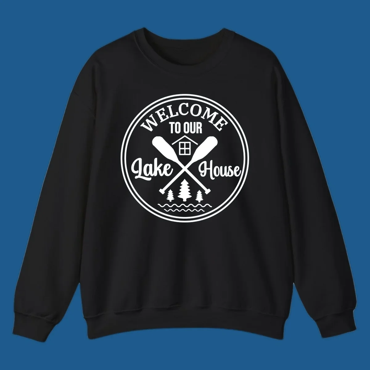 Circular badge design with text 'WELCOME TO OUR Lake House', crossed oars, house, trees, and waves.