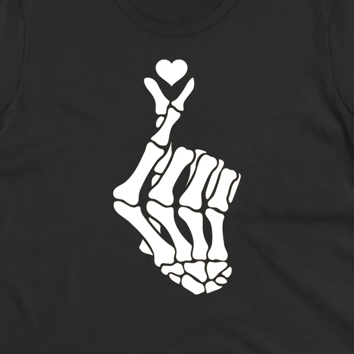A white skeleton hand forms the Korean finger heart gesture, with a small heart shape at the fingertips. Concept: skeleton-finger-heart.