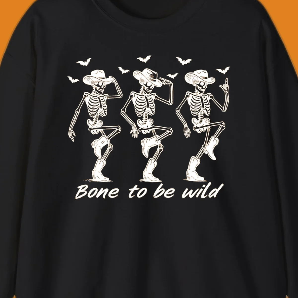 Three dancing skeletons in cowboy hats and boots with bats and the phrase 'Bone to be wild', bone-to-be-wild-cowboy