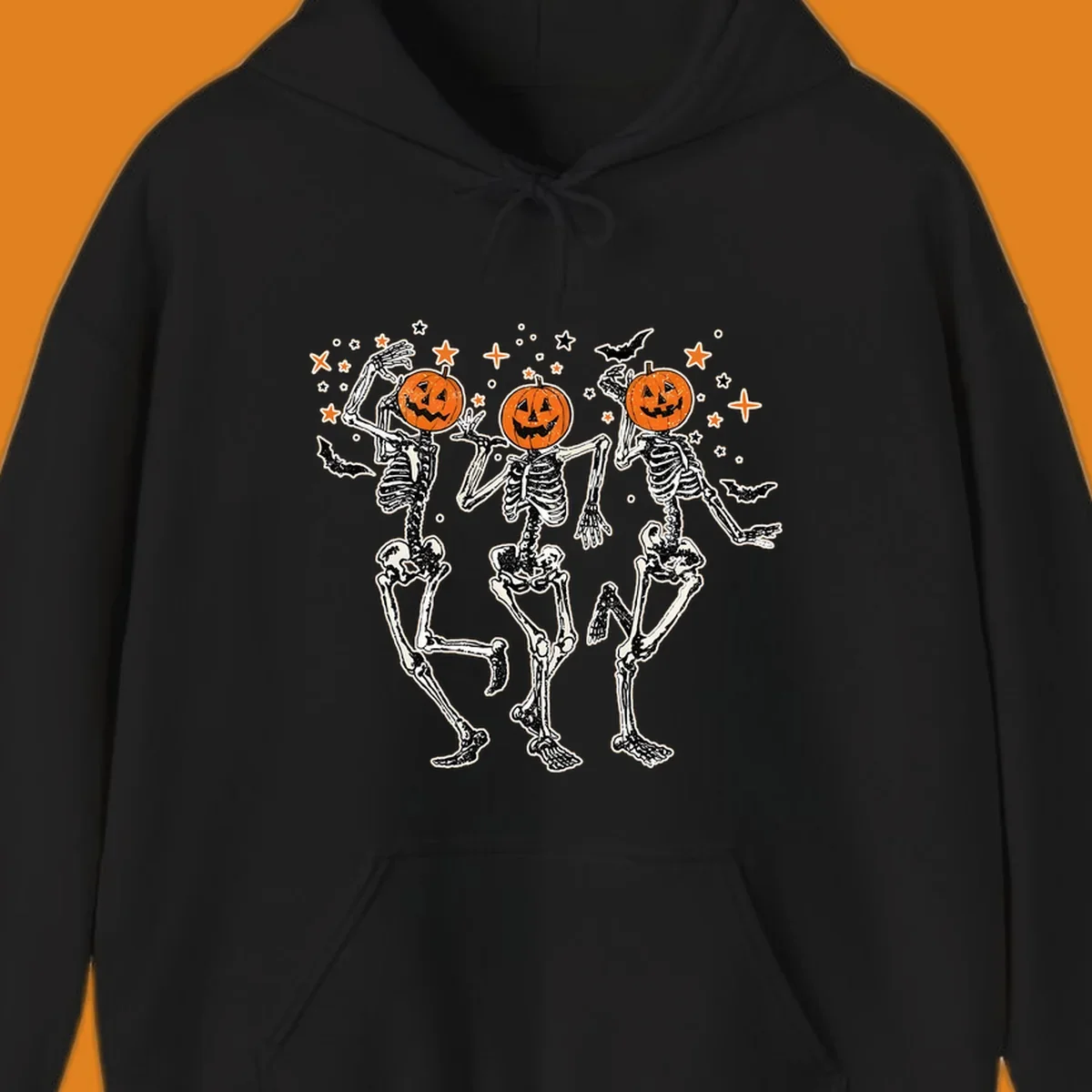 Dancing skeletons with pumpkin heads, bats, and stars illustration for Halloween.