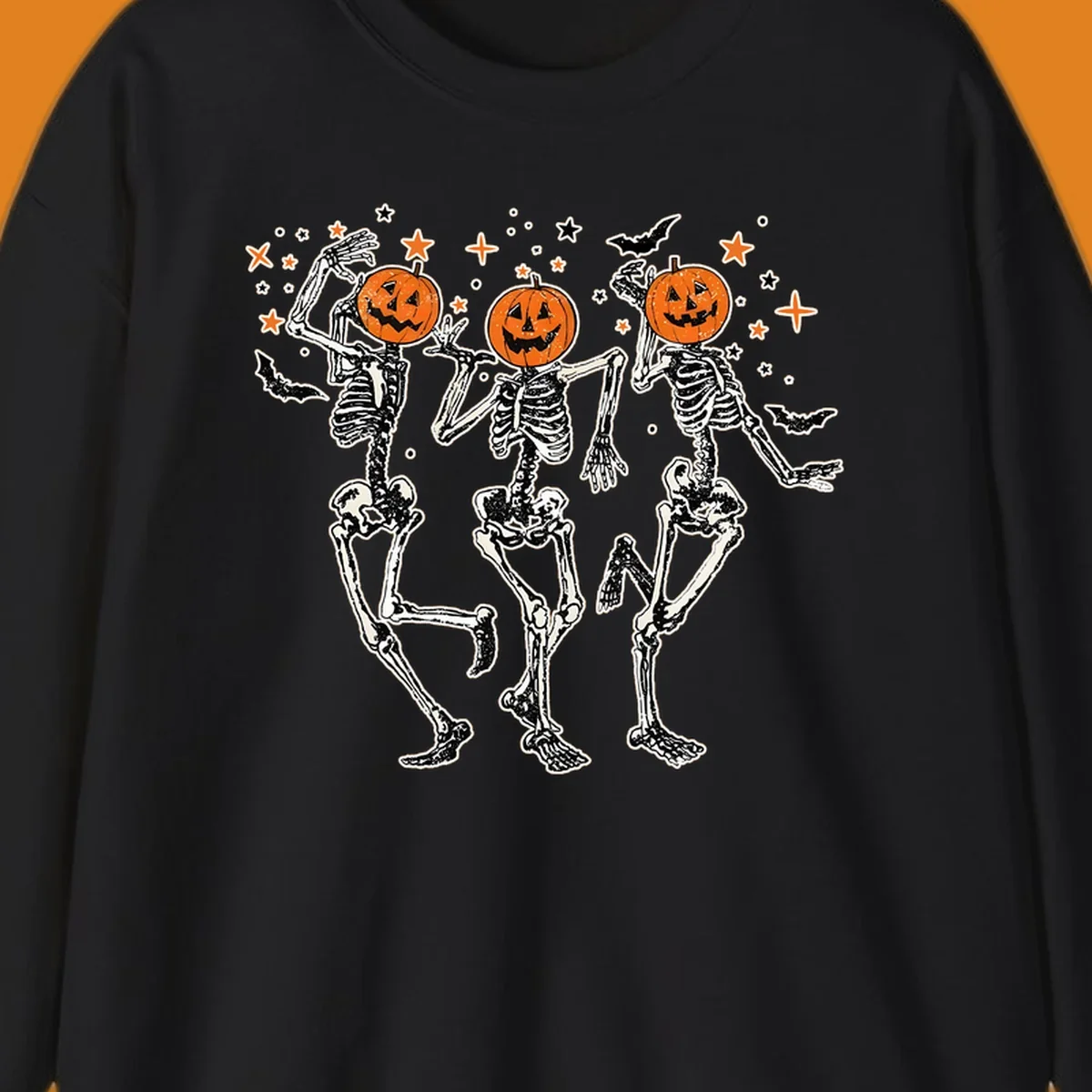 Dancing skeletons with pumpkin heads, bats, and stars illustration for Halloween.