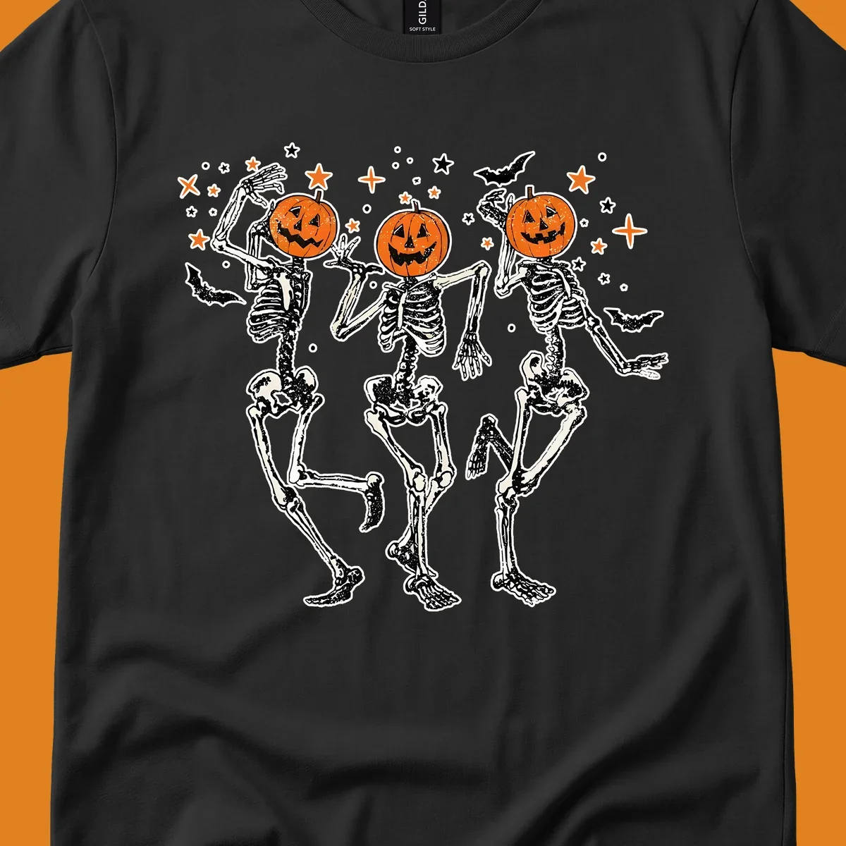 Dancing skeletons with pumpkin heads, bats, and stars illustration for Halloween.