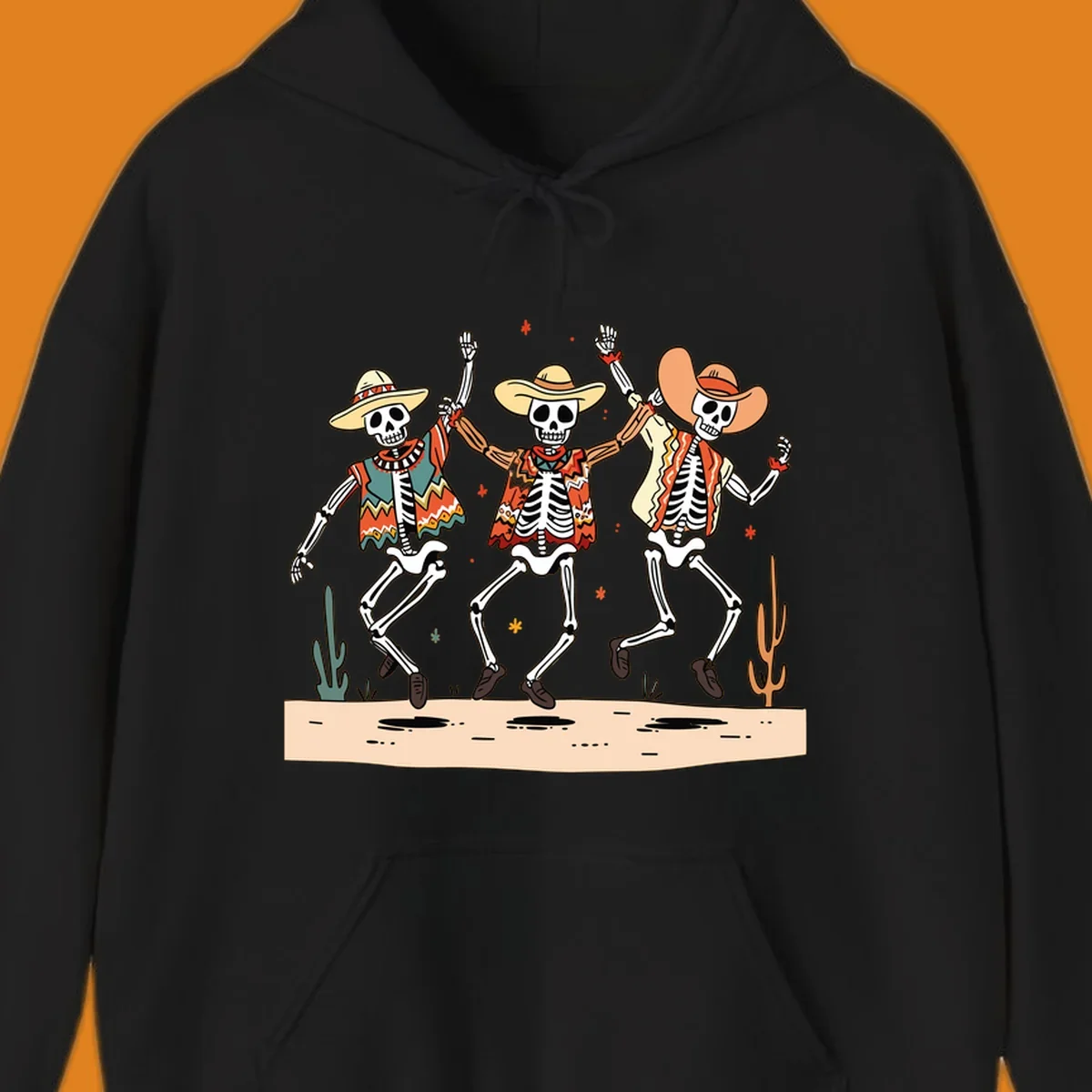 Three dancing skeletons in festive Mexican attire and sombreros, against a dark background with desert elements.