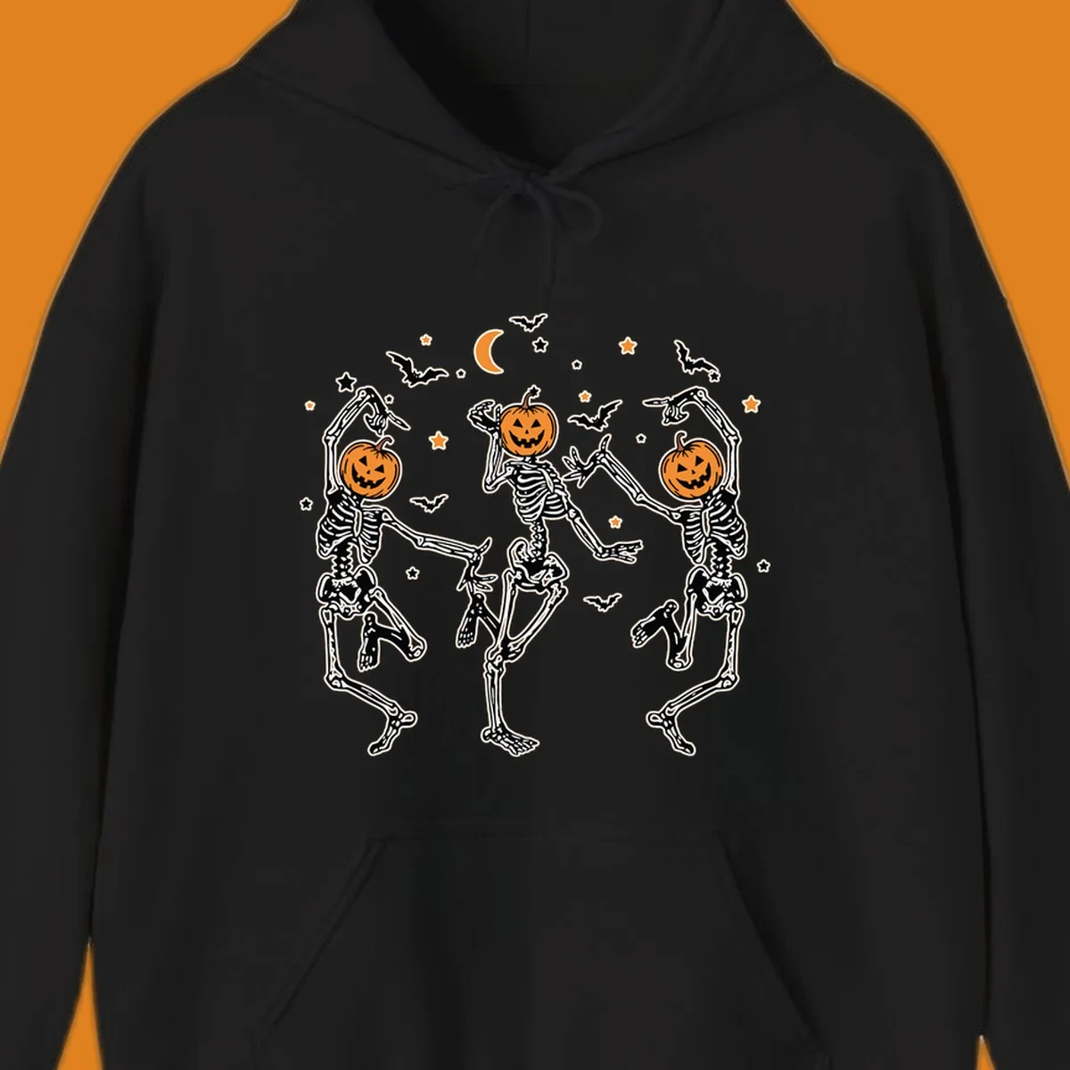 Three dancing skeletons with pumpkin heads, bats, moon, and stars illustration for Halloween.