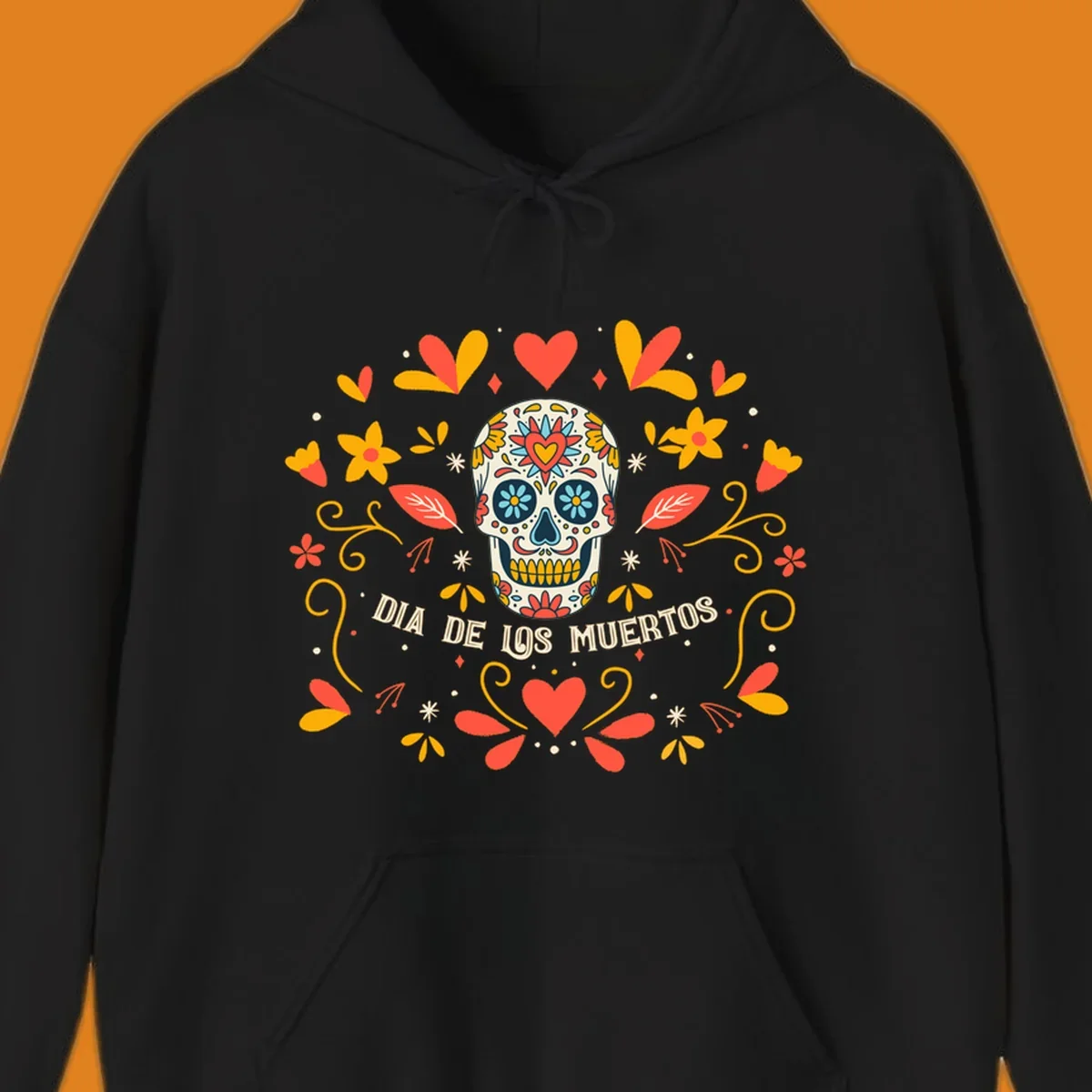 A colorful Día de los Muertos sugar skull with a heart on its forehead, surrounded by a symmetrical frame of red hearts, yellow flowers, and leaves, with 'DIA DE LOS MUERTOS' text below.