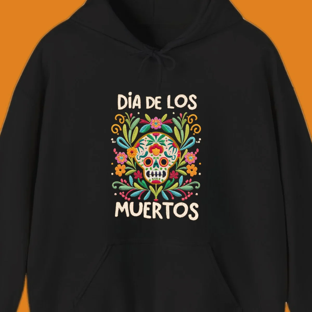 An embroidered-style Día de los Muertos sugar skull with colorful flowers and leaves, and the text "DÍA DE LOS MUERTOS".