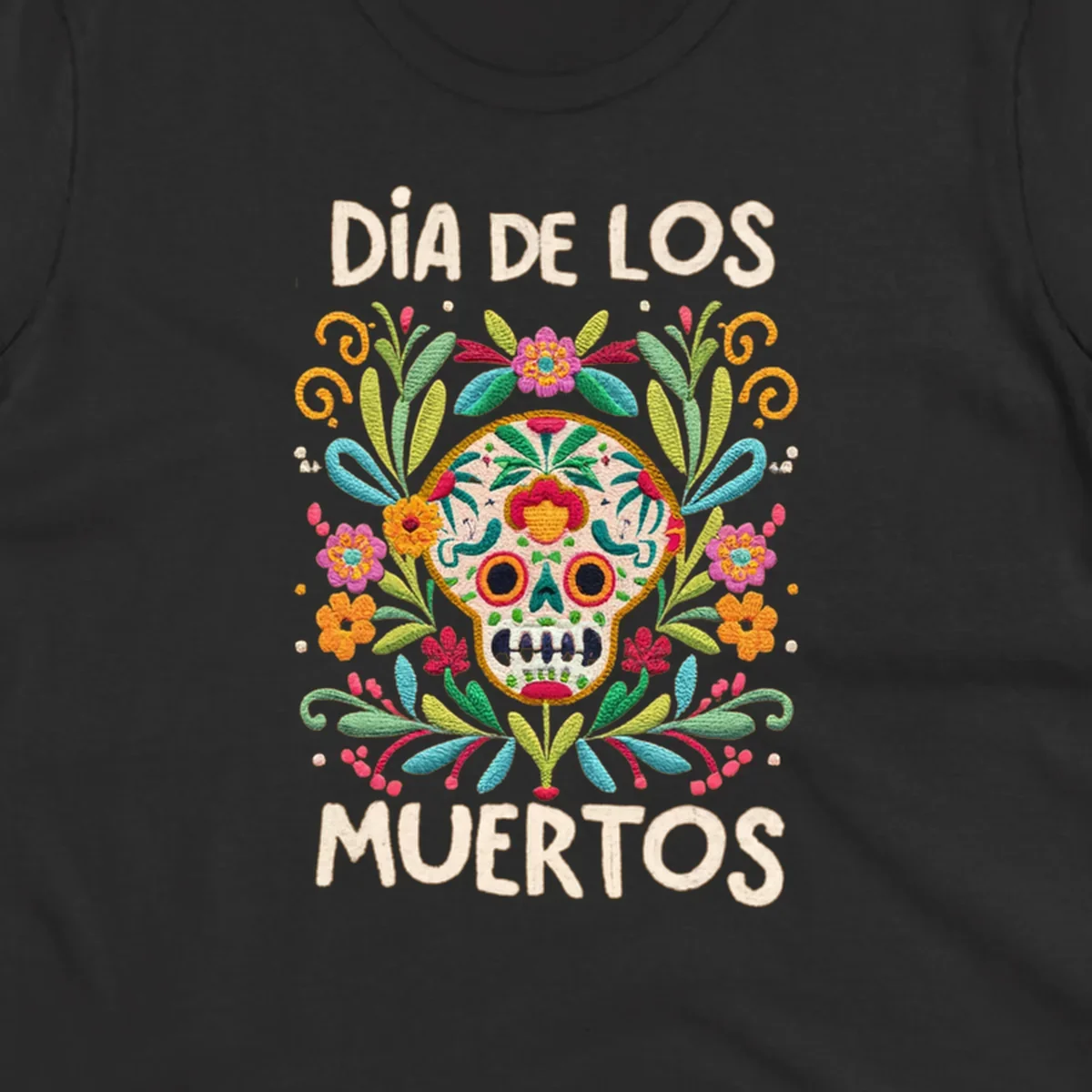 An embroidered-style Día de los Muertos sugar skull with colorful flowers and leaves, and the text "DÍA DE LOS MUERTOS".