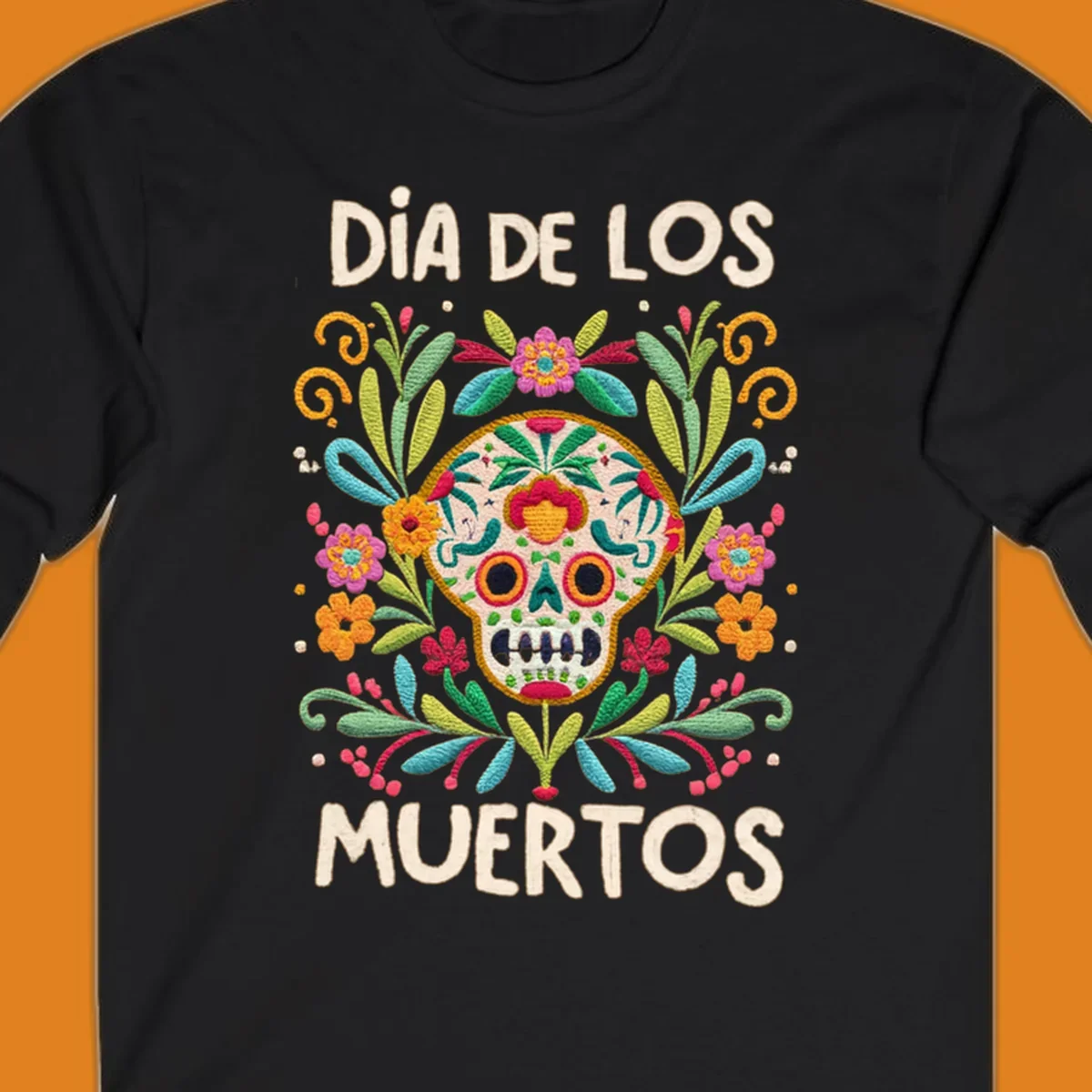 An embroidered-style Día de los Muertos sugar skull with colorful flowers and leaves, and the text "DÍA DE LOS MUERTOS".