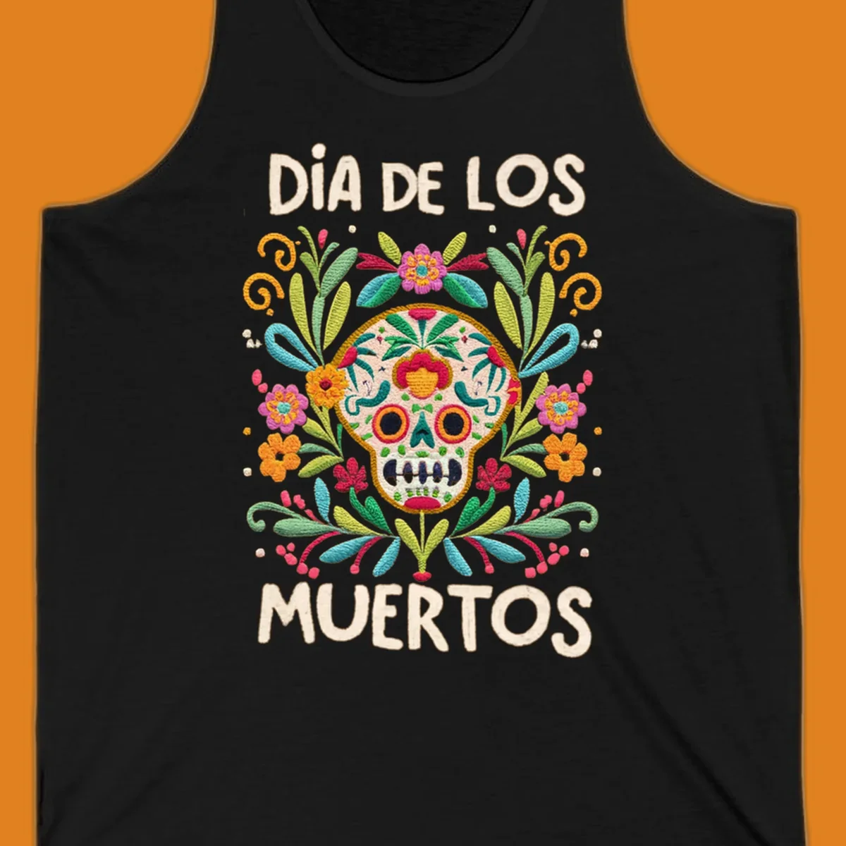 An embroidered-style Día de los Muertos sugar skull with colorful flowers and leaves, and the text "DÍA DE LOS MUERTOS".