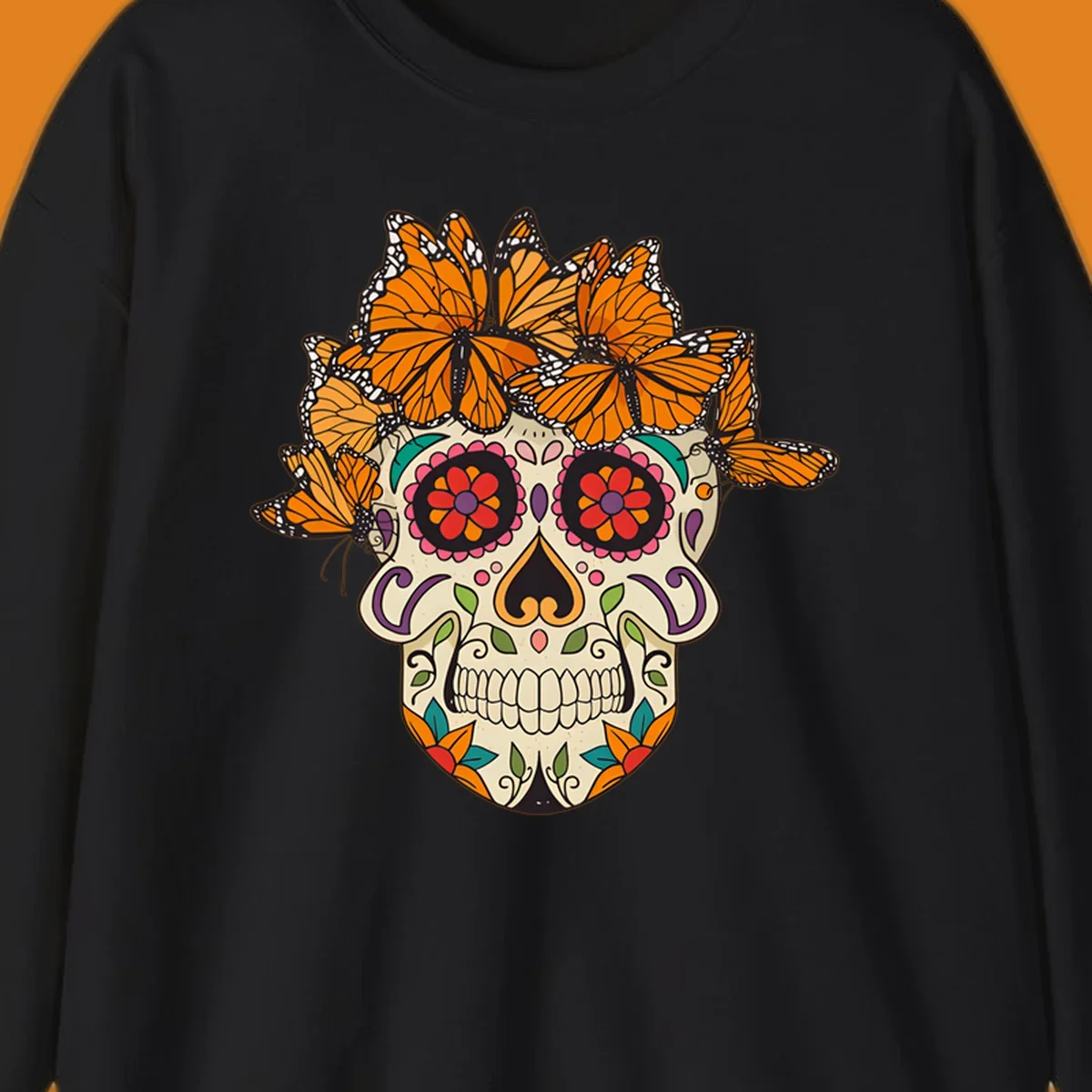 A cream sugar skull with colorful floral patterns and a crown of orange and black monarch butterflies.