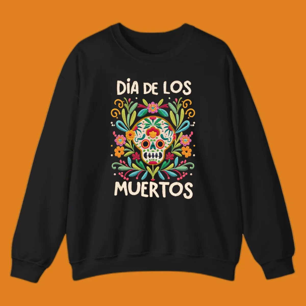 An embroidered-style Día de los Muertos sugar skull with colorful flowers and leaves, and the text "DÍA DE LOS MUERTOS".