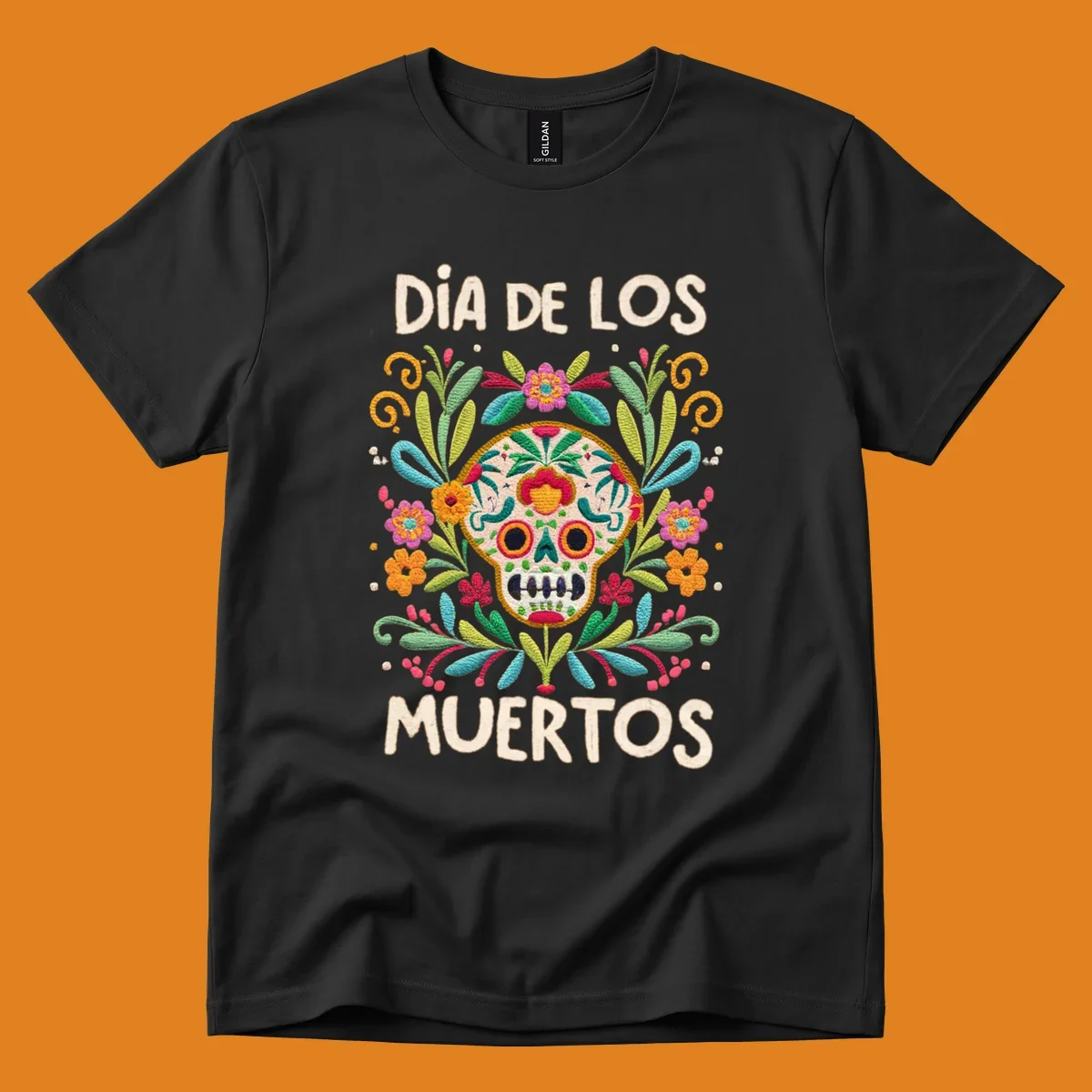 An embroidered-style Día de los Muertos sugar skull with colorful flowers and leaves, and the text "DÍA DE LOS MUERTOS".