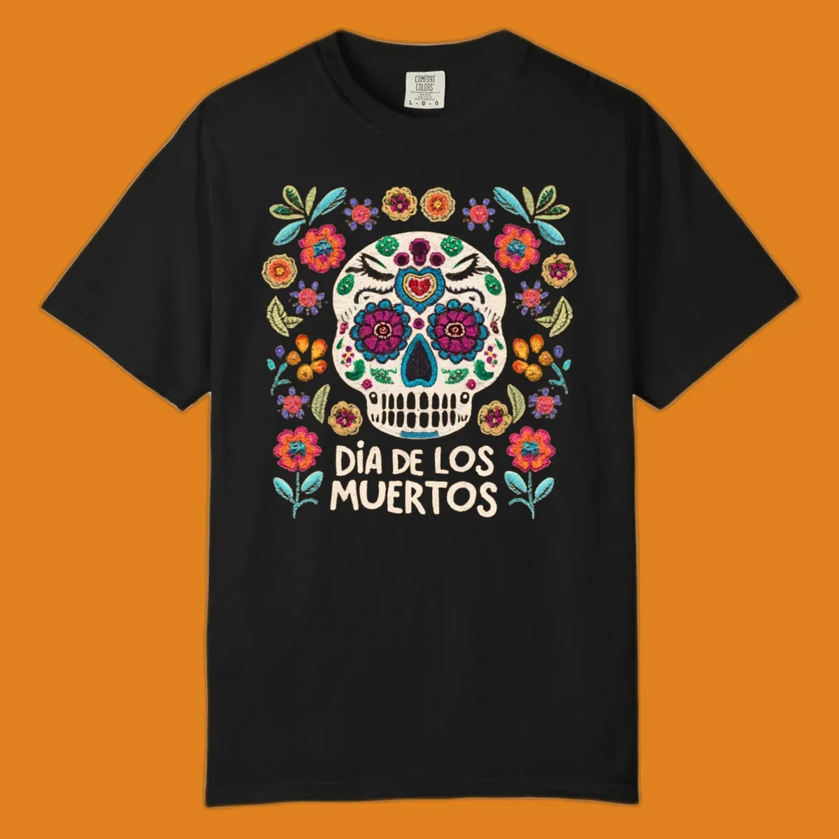Embroidered-style Día de los Muertos sugar skull with colorful flowers and leaves, and text 'DÍA DE LOS MUERTOS'.
