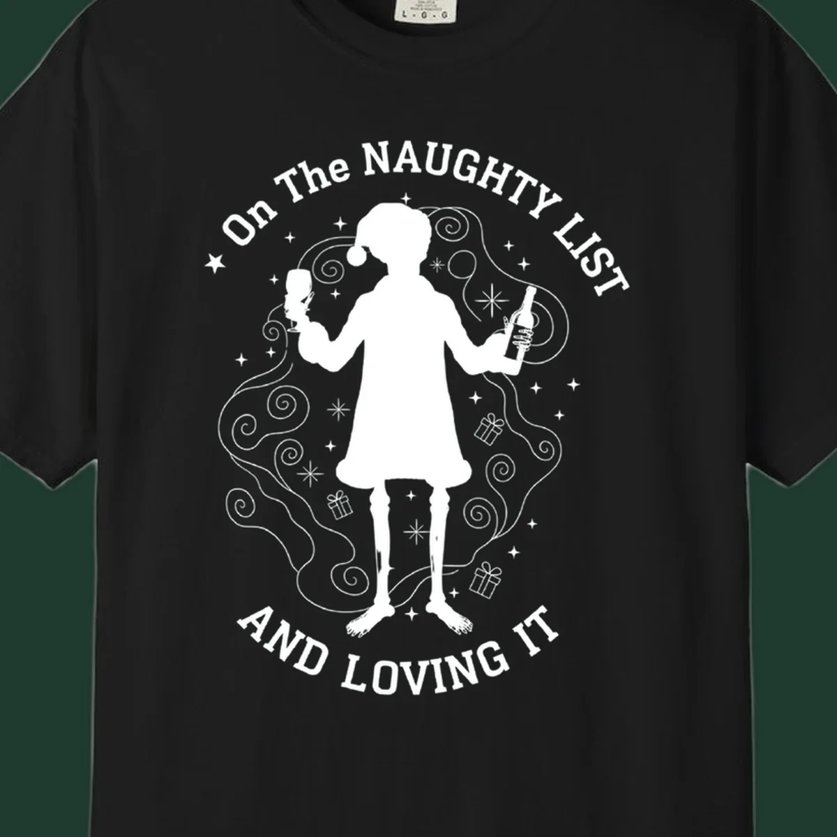Silhouette of person in Santa hat holding wine, text 'Naughty List And Loving It'.