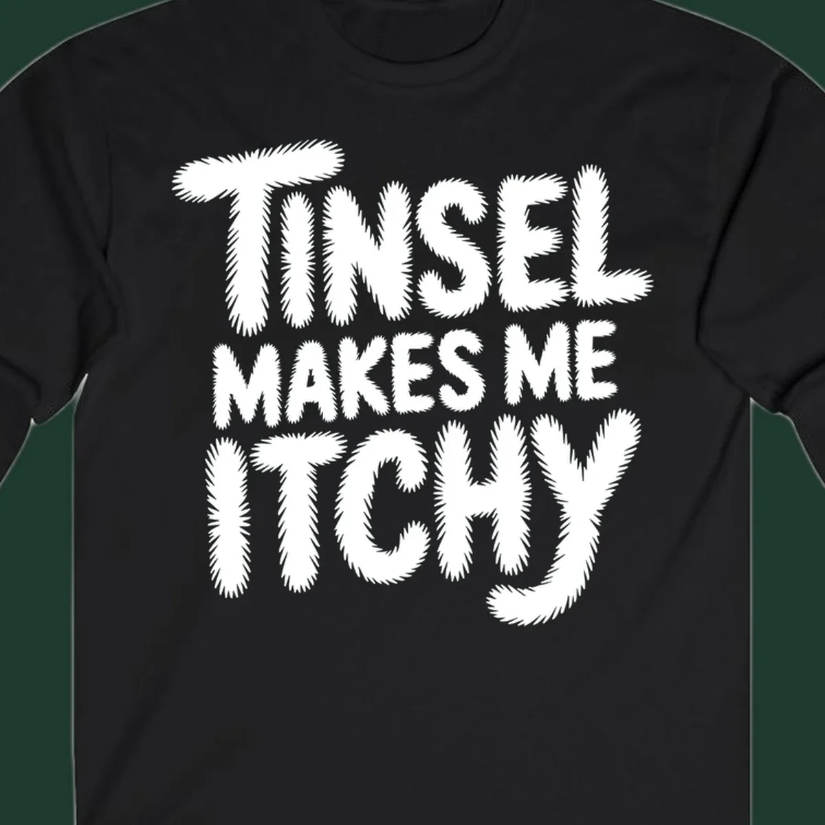 Text design reading "Tinsel Makes Me Itchy" in a fuzzy font.