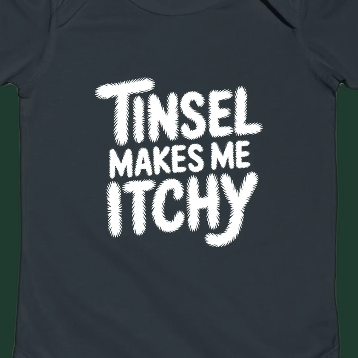 Text design reading "Tinsel Makes Me Itchy" in a fuzzy font.