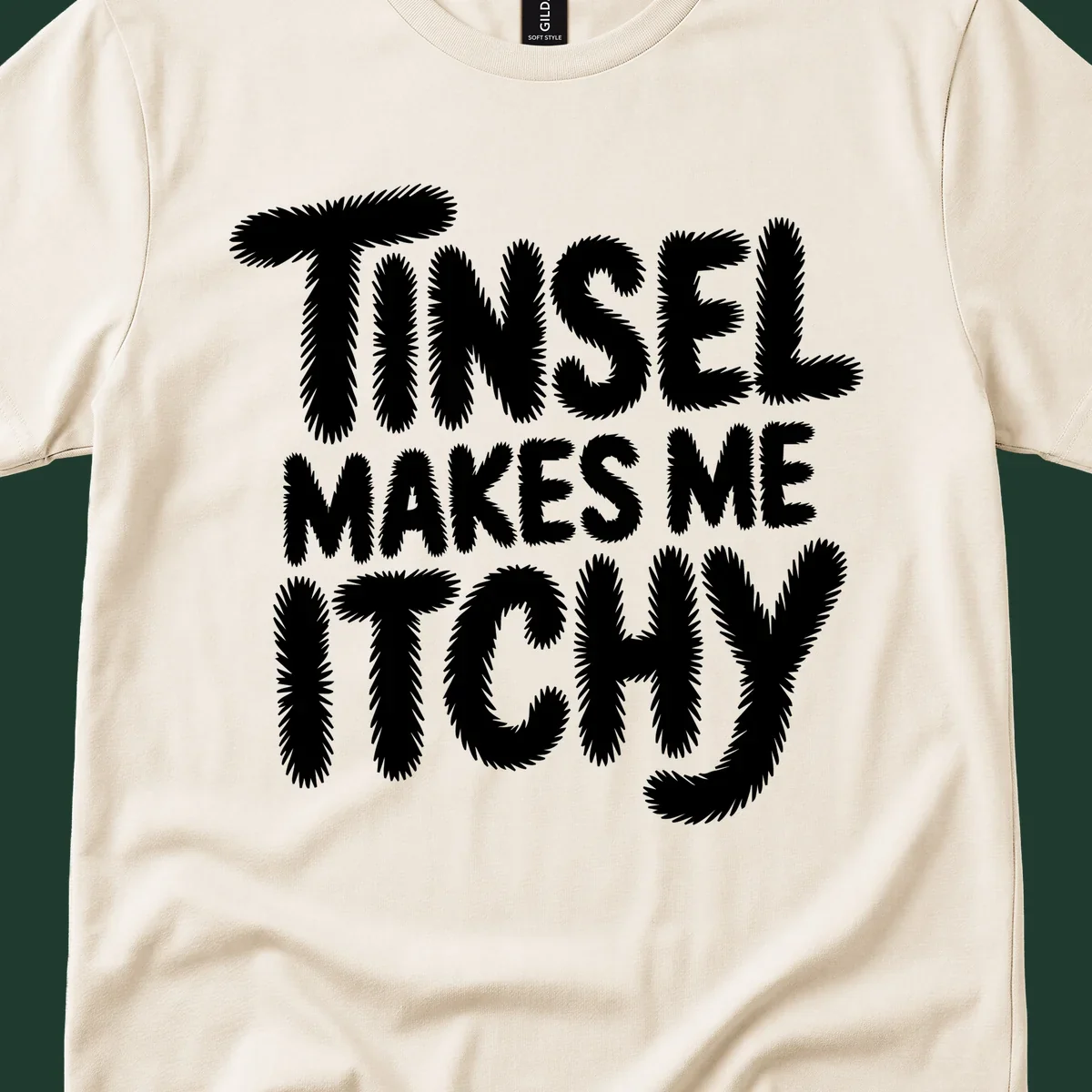 Text design reading "Tinsel Makes Me Itchy" in a fuzzy font.