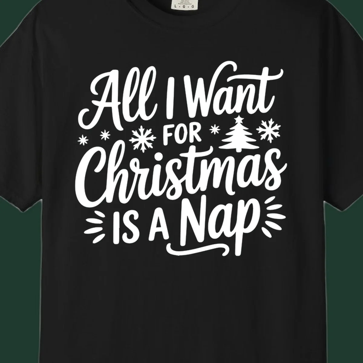 All I Want For Christmas Is A Nap typographic design with snowflakes and a Christmas tree.
