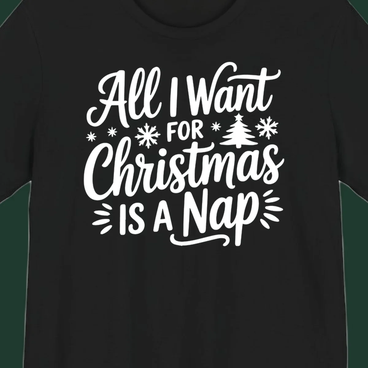 All I Want For Christmas Is A Nap typographic design with snowflakes and a Christmas tree.