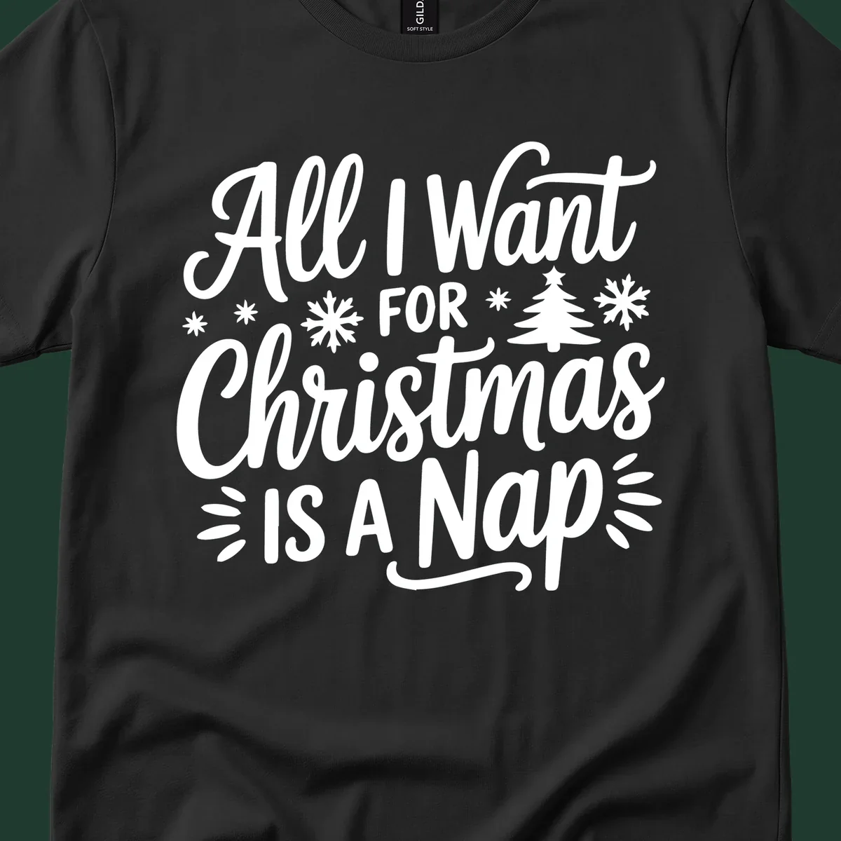 All I Want For Christmas Is A Nap typographic design with snowflakes and a Christmas tree.