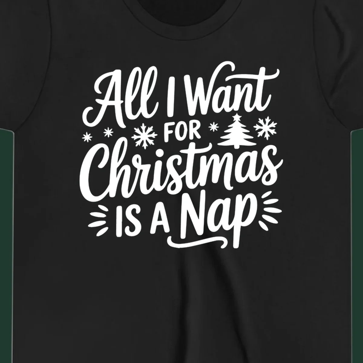 All I Want For Christmas Is A Nap typographic design with snowflakes and a Christmas tree.