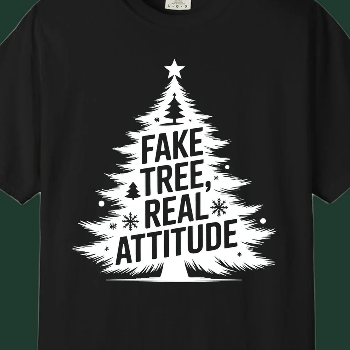 Christmas tree graphic with text 'FAKE TREE, REAL ATTITUDE' and snowflake accents.